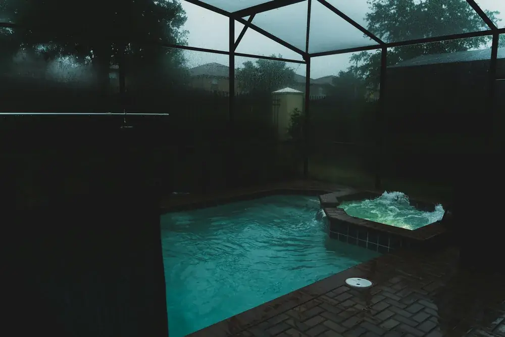 Screened pool enclosure over a pool and paver deck